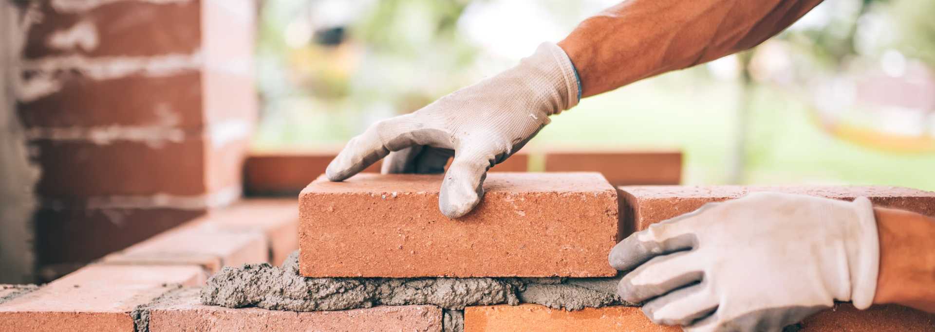 Handwerker baut Mauerziegel Wand